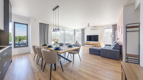 a dining room and living room with a table and chairs at Sand Dunes, Sun & Snow in Dziwnów
