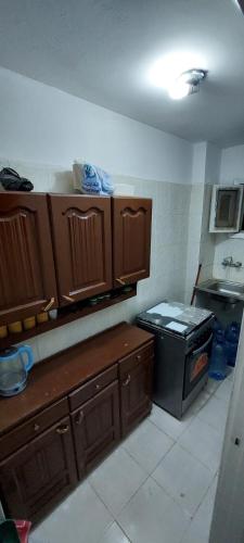 a kitchen with wooden cabinets and a stove in it at قرية الخليج الكاسح in Marsa Matruh
