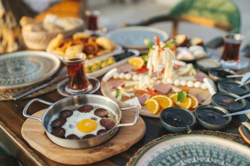 a table with a breakfast of eggs and food at İncebey Konak Cappadocia in Uçhisar