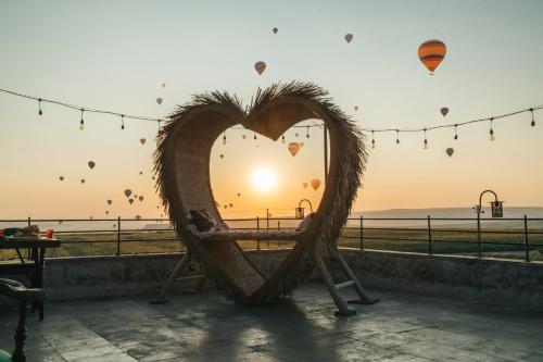 a heart shaped bench with the sunset in the background at İncebey Konak Cappadocia in Uçhisar