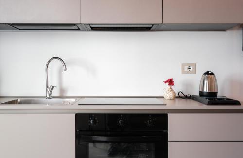 a kitchen counter with a sink and a stove at Eleia Mirea in Monopoli