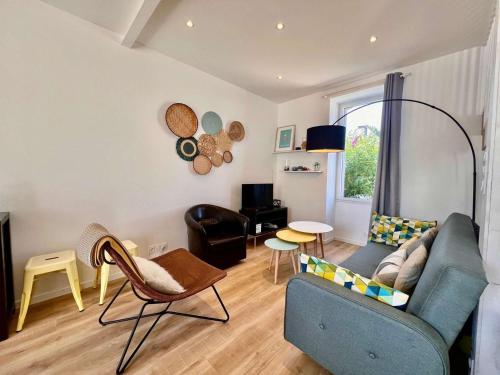 un salon avec un canapé bleu et des chaises dans l'établissement Maison T5 rénovée à Quiberon, 4 chambres, jardin, proche plage, classée 2 étoiles - FR-1-478-205, à Quiberon