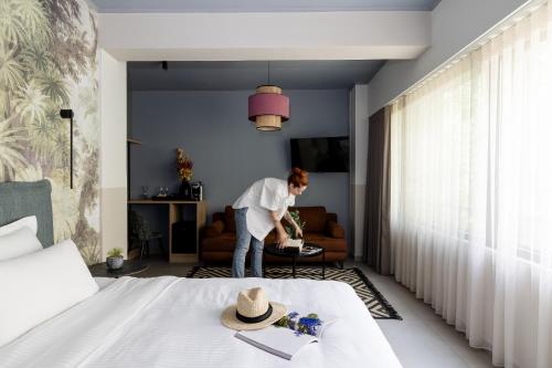 a woman standing in a bedroom with a bed at Airio Athens Suites in Athens