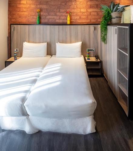 a large white bed in a room at ONOMO Hotel Durban in Durban