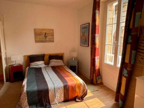 - une chambre avec un lit et une couverture colorée dans l'établissement Quiberon - Maison 5 pièces - Calme - 50m plage, jardin, animaux admis - FR-1-478-170, à Quiberon