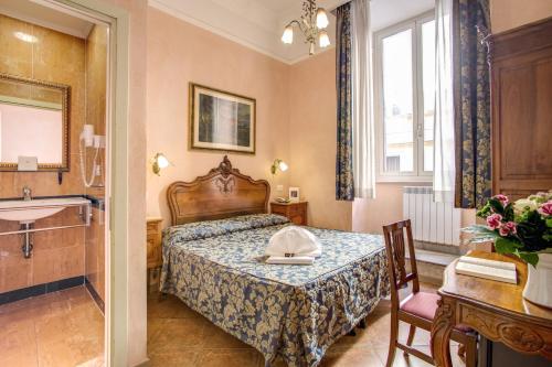 a bedroom with a bed and a table with a hat on it at Hotel Caravaggio in Rome