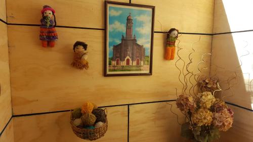 a wall with a picture of a church and baskets at Hostal Vista al Mar hct in Ancud