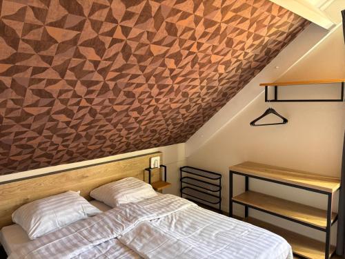 a bedroom with a bed next to a desk and a wall at Zeer comfortabel vakantiehuis op kleinschalig park 6 personen in Ewijk