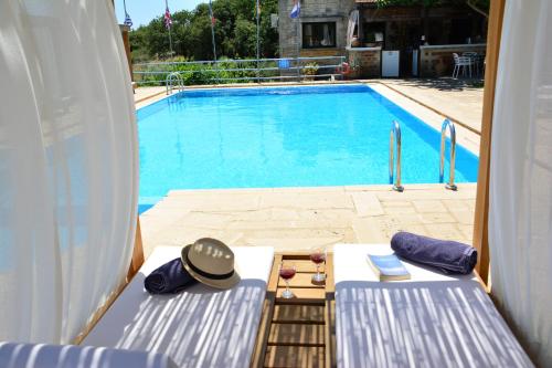 a view of a swimming pool with two chairs and a hat at Elianthos Villas in Vamos