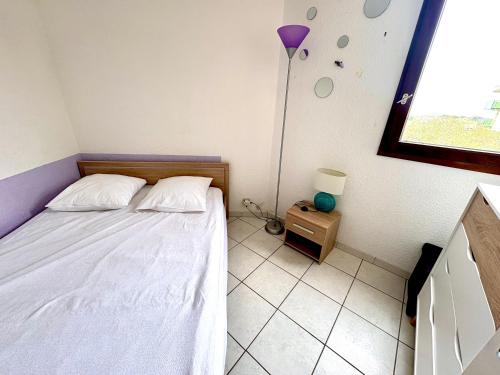 - une petite chambre avec un lit et une lampe dans l'établissement Appartement T2 cabine SAINT CYPRIEN plage, à Saint Cyprien Plage