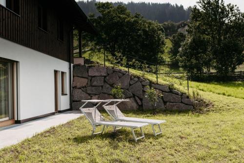 two white chairs and a table in the grass at Baumannhof in Sarntal