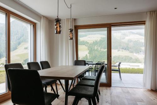 a dining room with a table and chairs and a large window at Baumannhof in Sarntal