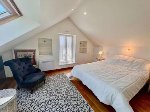 une chambre avec un grand lit et une chaise bleue dans l'établissement Maison 4 pièces avec jardin clos, terrasse et WIFI - Proche plage et commerces - Animaux admis - FR-1-478-250, à Quiberon