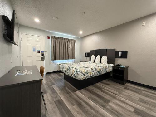 a hotel room with a bed and a desk at Studio 6 Tacoma, WA - South in Tacoma