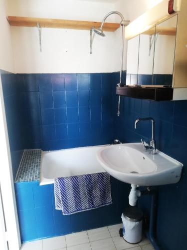 La salle de bains bleue et blanche est pourvue d'un lavabo et d'une baignoire. dans l'établissement Kaban On, à Marseille