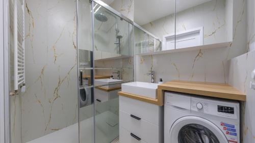 a bathroom with a washing machine and a washer and dryer at Sand Dunes, Sun & Snow in Dziwnów