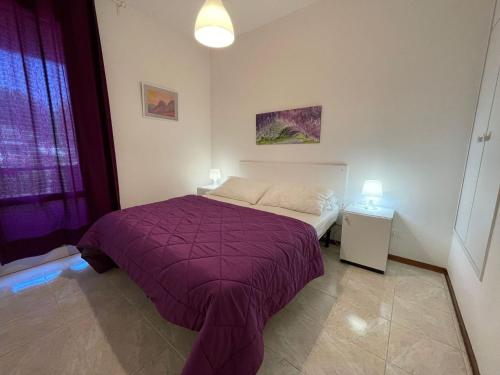 una camera con un letto e una coperta viola di Villa with private garden and barbecue a Porto Santa Margherita di Caorle