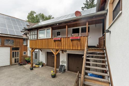 a house with a staircase and a house with solar panels at Ferienwohnung Sonnenblume in Rhadern