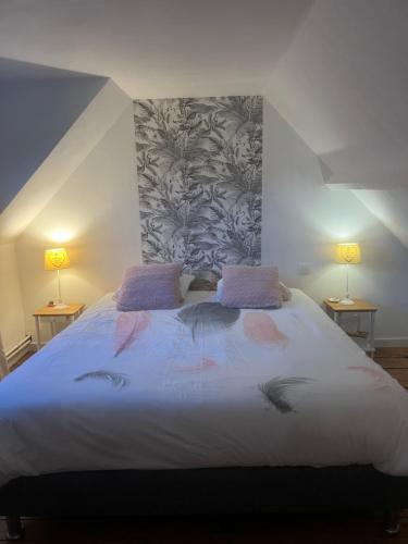 une chambre avec un grand lit avec deux lampes dans l'établissement La lumière bleue, à Tourville-sur-Arques