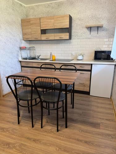 a kitchen with a table and two chairs and a counter at Domki u Piotrusia in Żarnowska