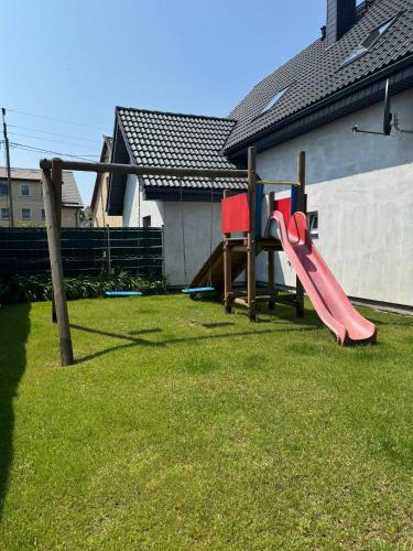 a playground with a pink slide in a yard at Domki u Piotrusia in Żarnowska