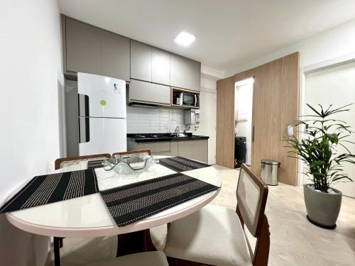 cocina con mesa blanca y nevera blanca en Apartamento Nobre - Próximo do Minas Centro e Mercado Central BH, en Belo Horizonte
