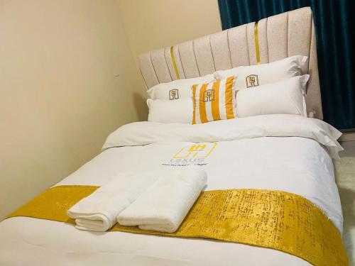 1 cama con 2 almohadas y toallas en Lexus Homes, en Nakuru
