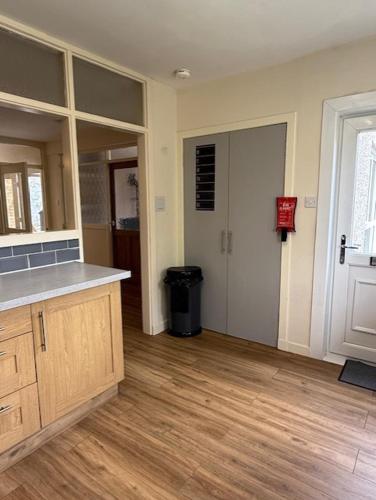 a kitchen with a counter and a hallway with a door at Lomond Villa in Fort William