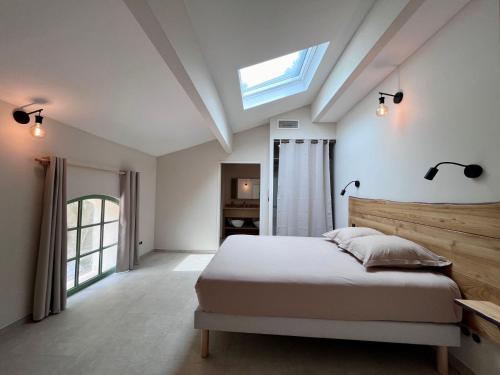 une chambre avec un lit et une lucarne dans l'établissement Villa Les Charmes, à Narbonne