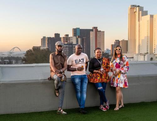 a group of people sitting on a wall in front of a city at ONOMO Hotel Durban in Durban
