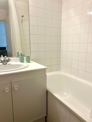 une salle de bain avec un lavabo, une baignoire et un miroir dans l'établissement Le petit Apollon - T2 Climatisé, à Toulouse