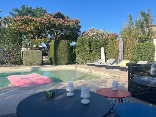 - une piscine avec 2 tables et des chaises dans la cour dans l'établissement Superbe villa de plain pied avec piscine et jardin, à Pérols