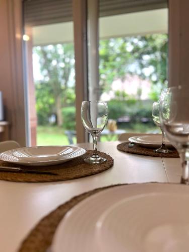 - une table avec deux assiettes et des verres à vin dans l'établissement Le petit Apollon - T2 Climatisé, à Toulouse