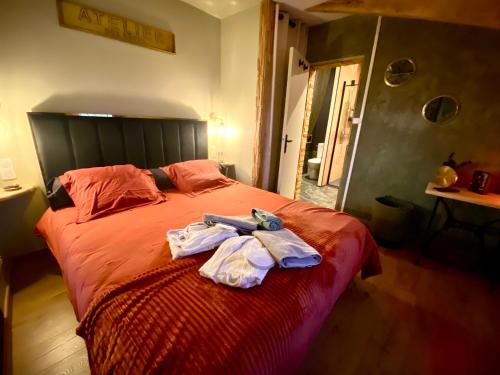 a bedroom with a bed with two towels on it at Maison romantique avec Balnéo Duo in La Bernerie-en-Retz