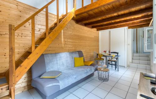 - un salon avec un canapé bleu et un mur en bois dans l'établissement Gorgeous Home In Saint-Jean-D'angély, à Saint-Jean-dʼAngély