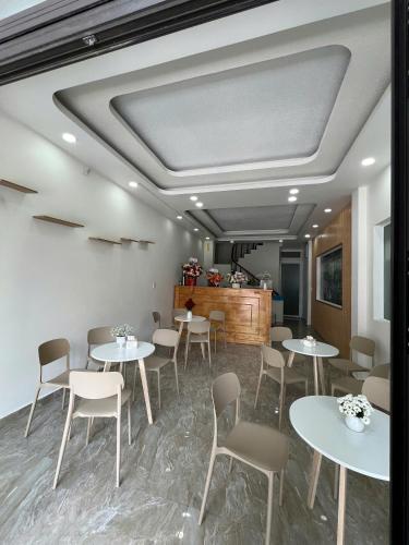 a restaurant with white tables and chairs and a counter at Mập's Soul Hostel Đà Lạt in Da Lat