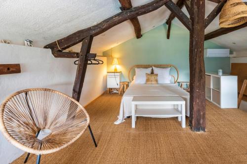 a bedroom with a white bed and a chair at La Caseta in Estang