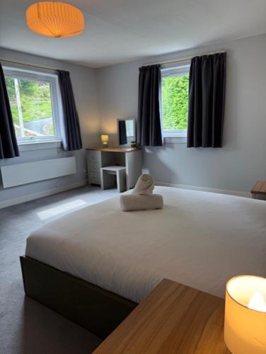 a bedroom with a large bed with a stuffed animal on it at Lomond Villa in Fort William