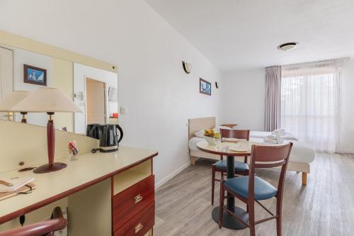 a room with a kitchen and a dining room at Appart'City Classic Lyon Villeurbanne in Villeurbanne