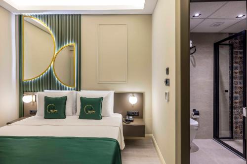 a bedroom with a bed with two green pillows at Sistina Old City Hotel in Istanbul