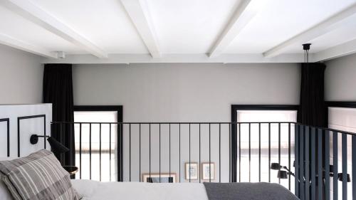a bedroom with a bed and a balcony with windows at Morgan & Mees Amsterdam in Amsterdam