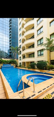 a swimming pool in front of a large building at Studio Retreat in the Heart of Parramatta in Sydney