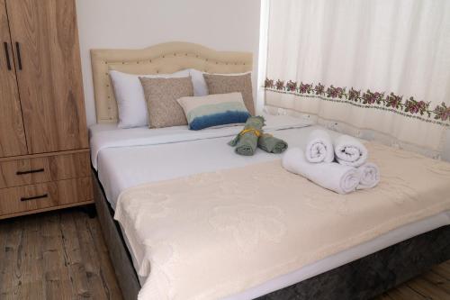 a bed with towels and two stuffed animals on it at Çağlar my hause apart otel in Turgutreis