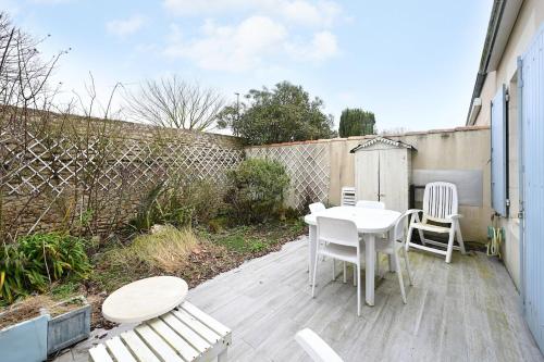 eine Terrasse mit Tisch und Stühlen und einem Zaun in der Unterkunft Vauban 125 Courtyard and parking in Saint-Martin-de-Ré