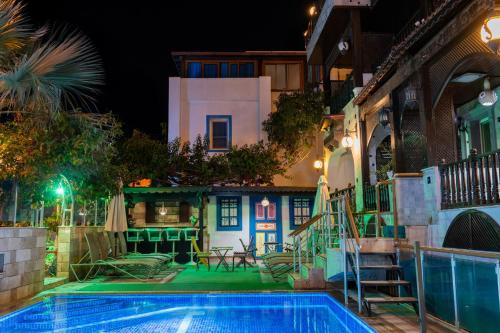 a villa with a swimming pool at night at Çağlar my hause apart otel in Turgutreis