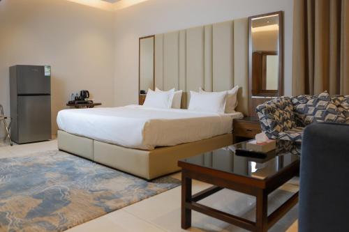 リヤドにあるسمت النرجس للشقق المخدومة - Samt Al Narjis Serviced Apartmentsのベッドとソファのあるホテルの部屋