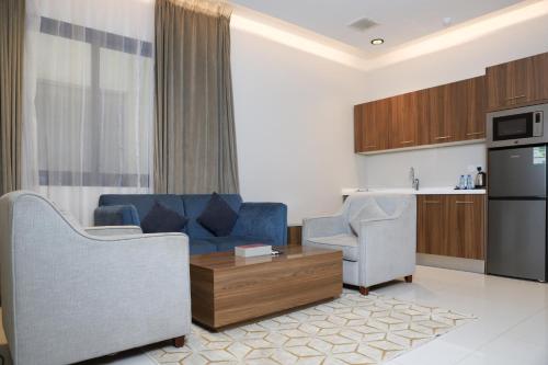 リヤドにあるسمت النرجس للشقق المخدومة - Samt Al Narjis Serviced Apartmentsのリビングルーム(ソファ、椅子2脚付)、キッチンが備わります。