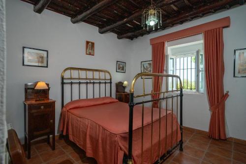 una camera da letto con un letto e una finestra di Cortijo señora de las Angustias 1 ad Alanís