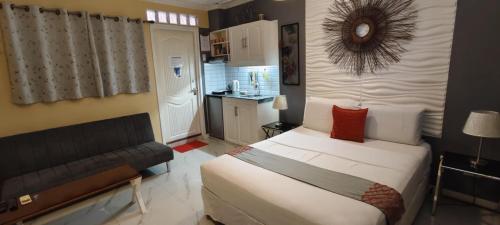 a bedroom with a bed and a couch in it at Little Norway Guesthouse - Mactan Cebu International Airport in Mactan