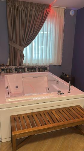 a large pink bath tub in a room with a window at La Piana Hotel in Tito
